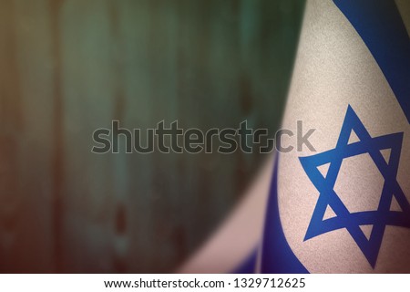 Israel hanging flag for honour of veterans day or memorial day on light blue blurred natural wood wall background. Israel glory to the heroes of war concept.