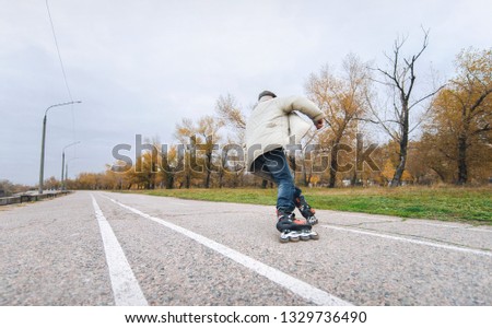 Active retiree rollerblading and making extreme turns. Autumn walks in the fresh air. Active old people.