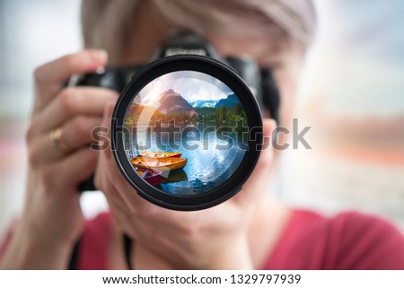 Outdoor travel lifestyle woman photographer shooting video camera at Alaska background. USA vacation holiday in Autumn.