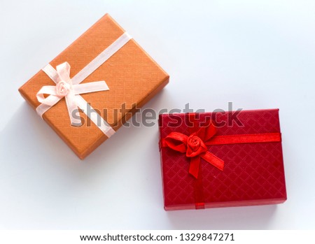Two gift boxes in red and orange on a white background
