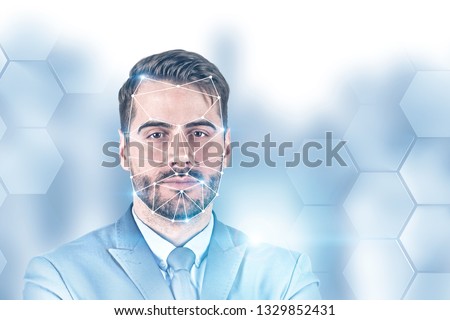 Portrait of bearded young businessman with face recognition technology. Blurred background with hexagonal pattern. Concept of hi tech. Toned image