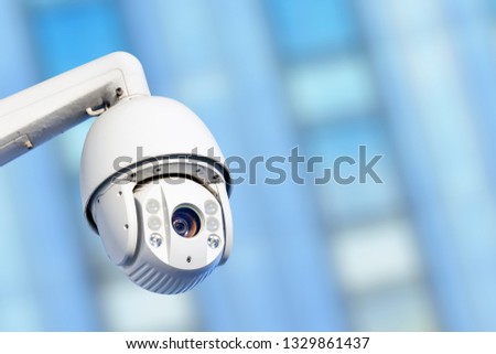 Close-up of modern CCTV camera with business buildings in the background