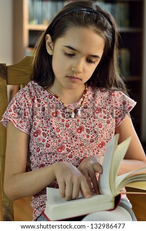 Little Hispanic Girl Reads a Book