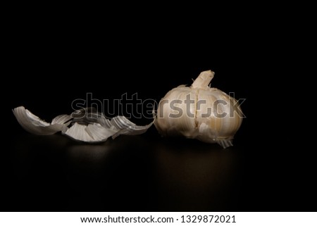 closeup peeled garlic on a black background with a free copy
