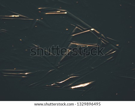Dark ice with evening sun flares. Nature art with small depth of field. Amazing natural background