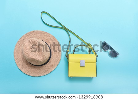 Summer collage with female hat ,sunglasses ,yellow  handbag –blue background
