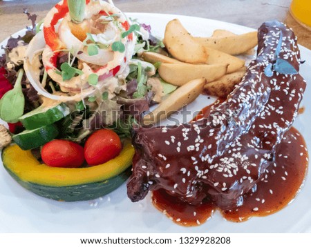 rib steak served with salad, French fries and a sauce