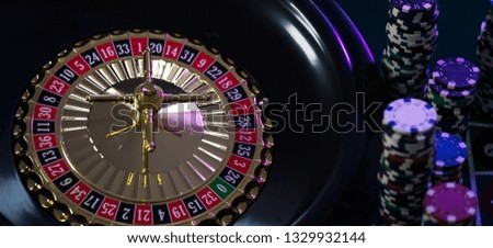 Casino background, poker Chips on gaming table, roulette wheel in motion.