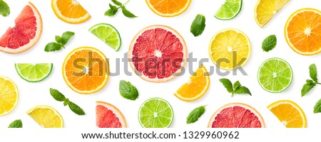Colorful pattern of citrus fruit slices and mint leaves isolated on white background. Top view, flat lay Royalty-Free Stock Photo #1329960962