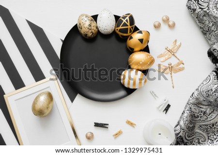 Happy Easter background with golden decorated eggs on black plate isolated on white background. Trendy flat lay easter. Card with copy space for text. Minimal easter concept