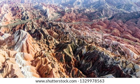 Top View of Rainbow Mountains Geological Park. Stripy Zhangye Danxia Landform Geological Park in Gansu Province, China. Drone Picture of Road in a Valley on a Sunny Day.