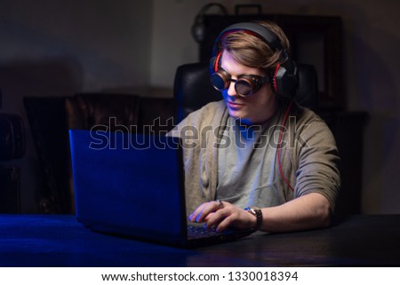 Hacker. A man at the computer. Hacking personal data. A man with glasses.
