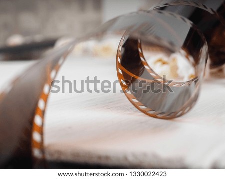 photographic film strip on white wooden background, popcorn.