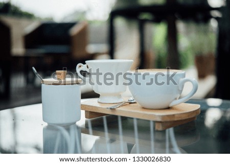 Hot latte art in coffee cup on wood table in coffee shop