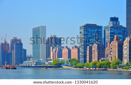  Modern architecture skyline with United Nations building against blue sky and in East River waterfront in Manhattan, New York