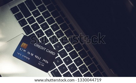 Credit cards, debit cards are on the laptop at the desk.