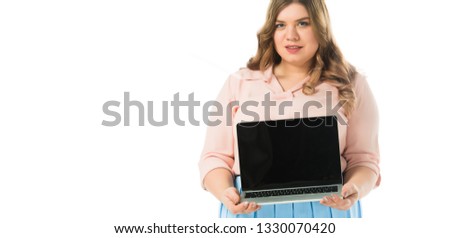 attractive elegant plus size girl showing laptop with blank screen isolated on white