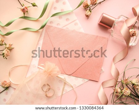 wedding card design. wedding rings, flowers and an envelope on a pink background . invitation. proposal. wedding