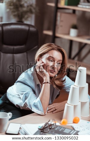 Trying to brainstorm. Beautiful mature businesswoman trying to brainstorm looking at plastic pyramid