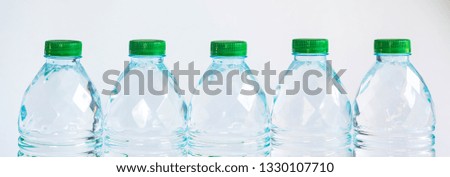 
Plastic water bottle and green lid on white