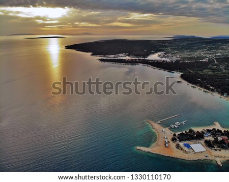 Drone photo of a camp on island Pag, Croatia, with a beautiful sunset in the background.