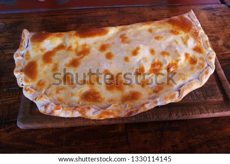 Big Empanada on plate, wooden table