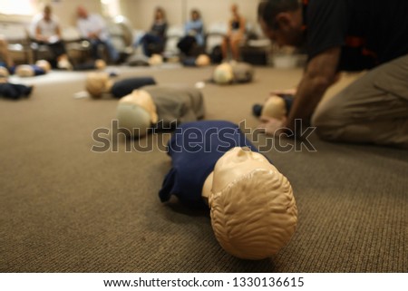 Safe workplaces clean picture of children dummy head with defocused of instructor demonstration how to CPR on children dummy with adult learners background   