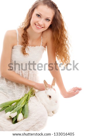 happy woman sitting on the floor with tulips and a rabbit