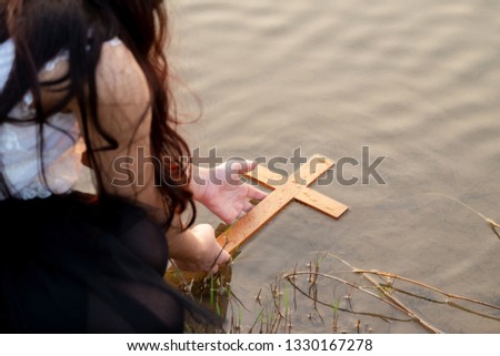 Girl Picking up the Wood Cross from the River, Concept Picture.