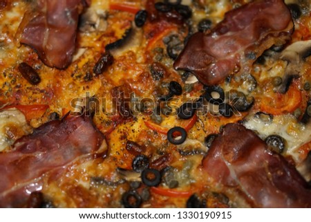 top of homemade pizza with Parma ham, black olives and capers
