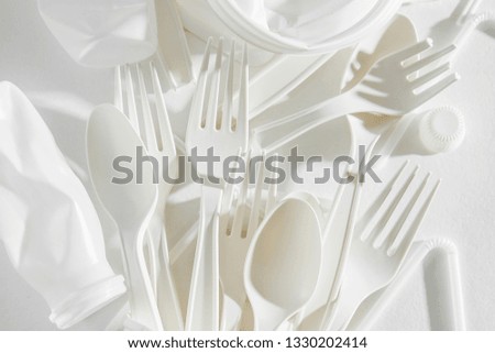 White single use plastic on  white background. Closeup. 
Concept of Recycling plastic and ecology. Flat lay, top view