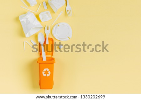 White single use plastic in garbage bin on  yellow background.
Concept of Recycling plastic. Flat lay, top view
