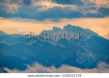 Beautiful distant winter mountains and skyscape with mist
