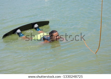 Woman study wakeboarding on a blue lake summer sports