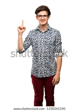 Teenager man with flower shirt and glasses showing and lifting a finger in sign of the best over isolated white background