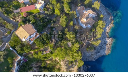 Homes above the ocean on a hill, overhead aerial view.