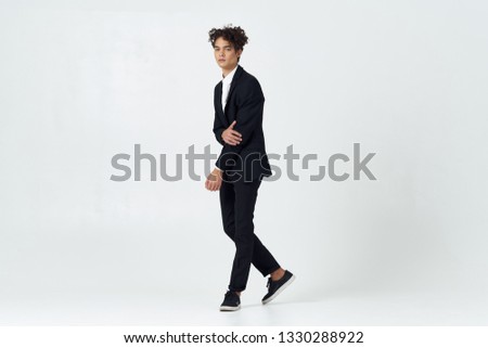 Handsome man with curly hair in a full-length suit office worker
