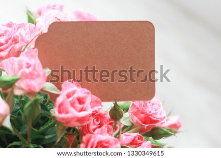 Paper badge in bunch of roses. Women day concept. Spring, 8 march, wish, copy space, craft, close-up
