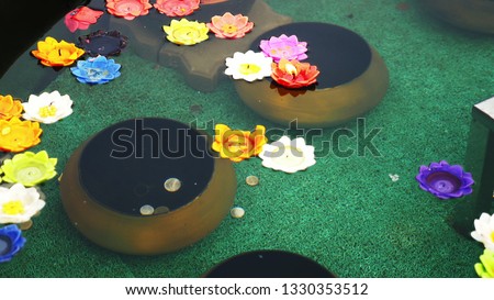 multicolored aroma candles in the form of a lotus flower in a bowl with water for offerings to the Buddha.