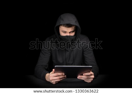 Hacker with tablet PC initiating cyber attack, isolated on black backgroung