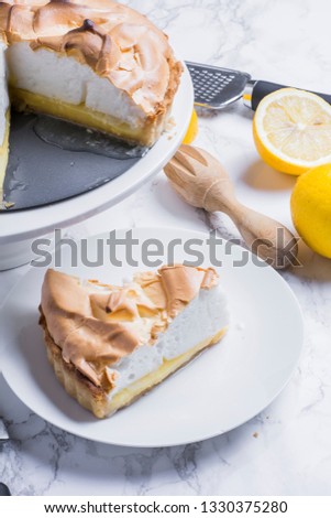 Lemon meringue pie with lemon and slice of pie