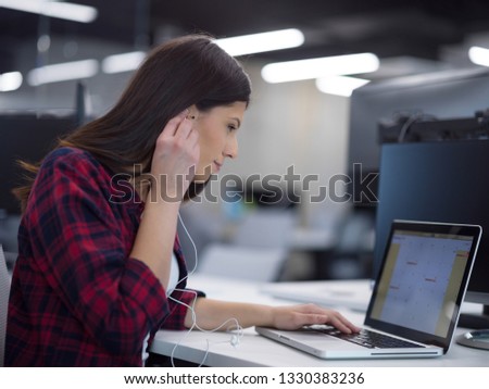 young female software developer using laptop computer while writing programming code at modern creative startup office