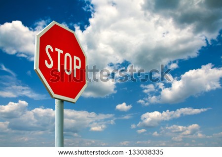 Red stop sign on the street, roadside traffic sign for stopping.