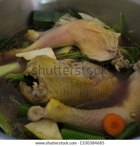 chicken soup with vegetables cooking in the pot
