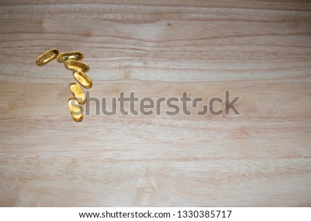 Cod Liver oil tablets on a wood background with space for text