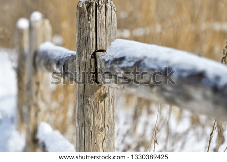 Old wooden fence in a farm snow covered in winter