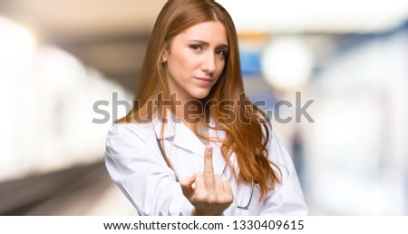 Redhead doctor woman making finger gesture in the hospital