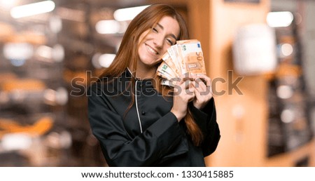 Young redhead chef woman holding a placard for insert a concept in the bakery
