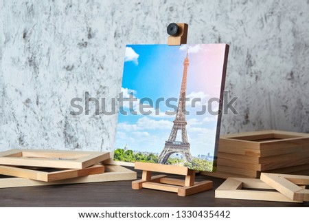 Canvas print: travel photography of Paris on a wooden easel and stretcher bars on table