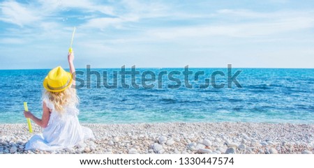 Little girl with soap bubbles on the sea